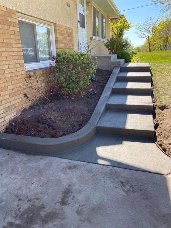 concrete stairs leading to brick home