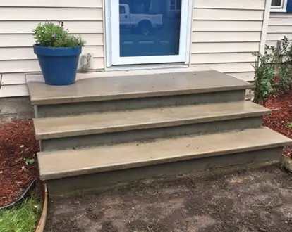 Concrete porch steps in front of blue door