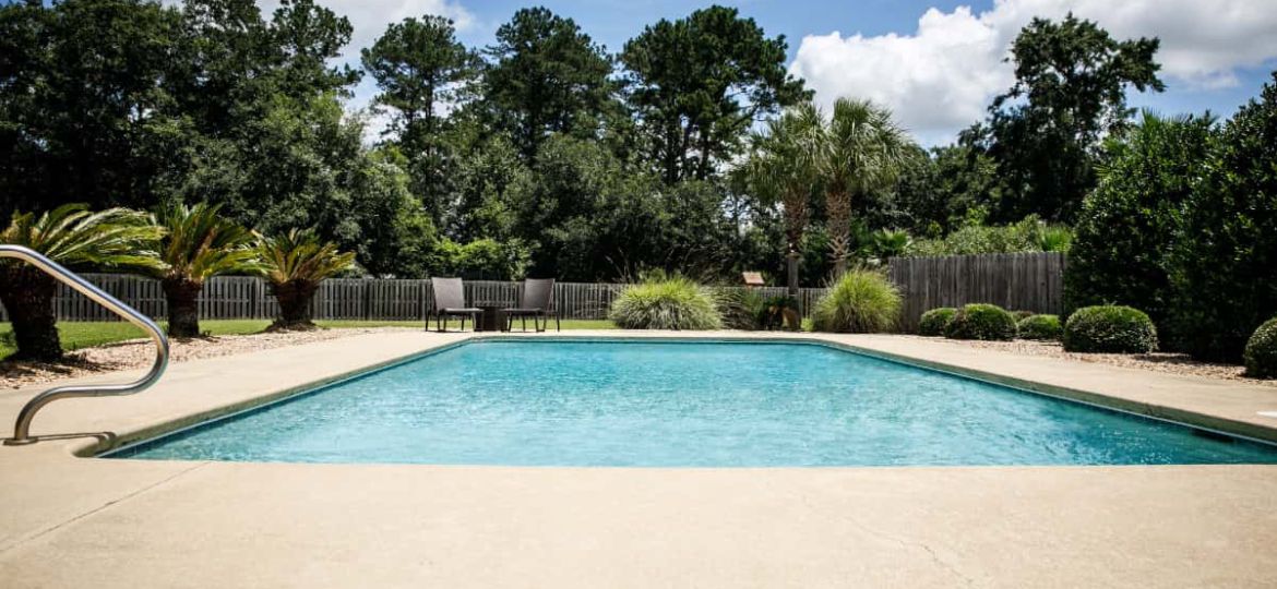 concrete pool deck with trees in background
